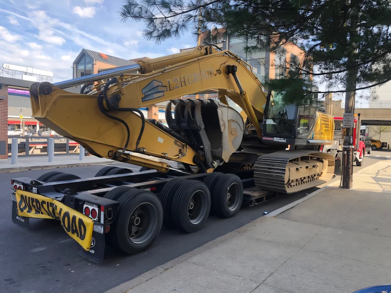 Yellow tracked excavator secured on a Campbell Logistics oversize-load lowboy trailer
