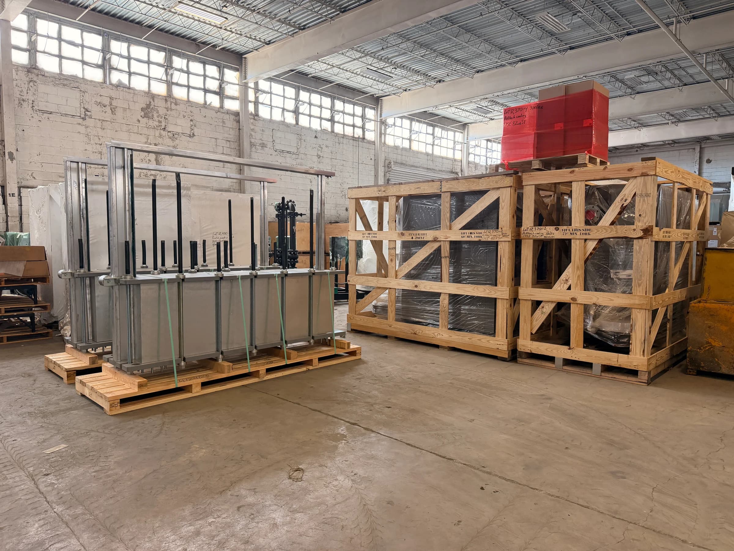 Industrial equipment on pallets and wooden crates inside a Campbell Logistics warehouse